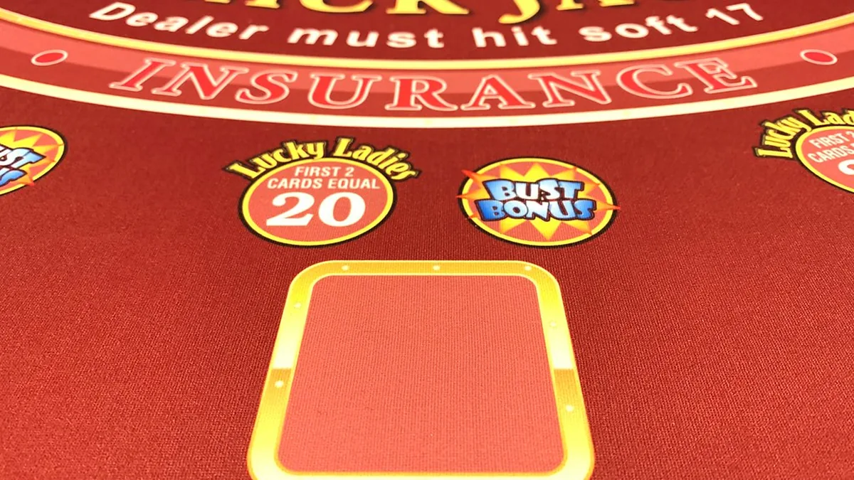 Close-up of a blackjack table layout with the insurance line and a betting box