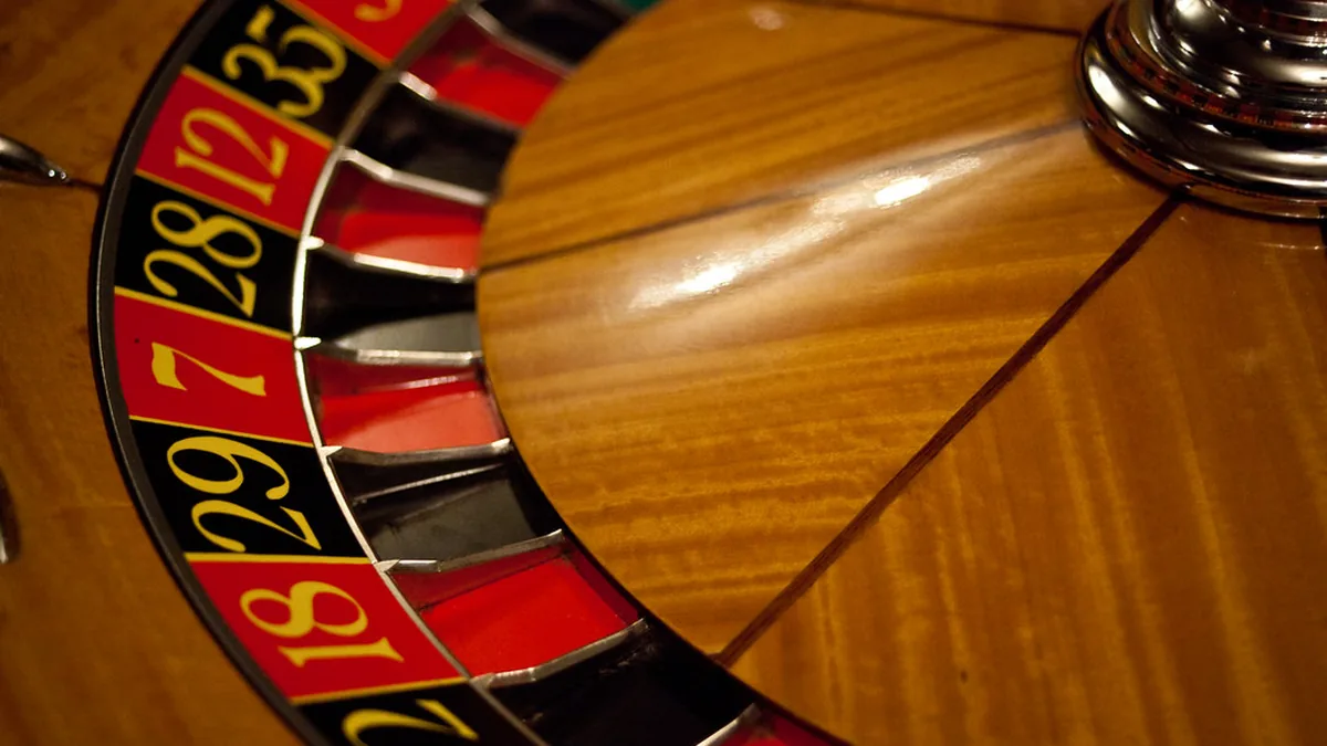 Close-up of a wooden roulette wheel with red and black numbered pockets