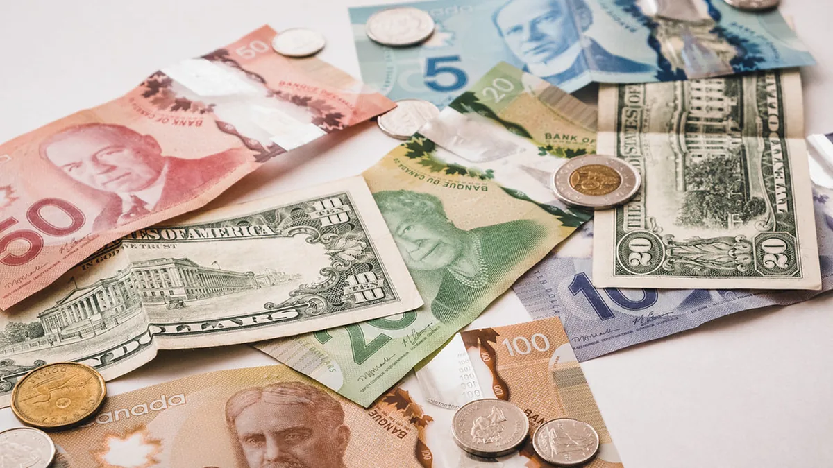 Canadian and US banknotes and coins spread on a table