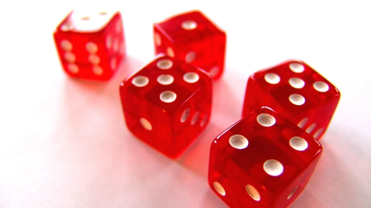 Five red translucent dice on a white surface