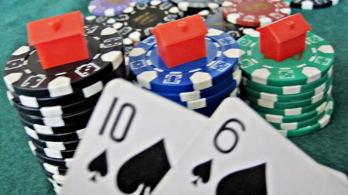 Stacks of casino chips on green felt with two playing cards in front
